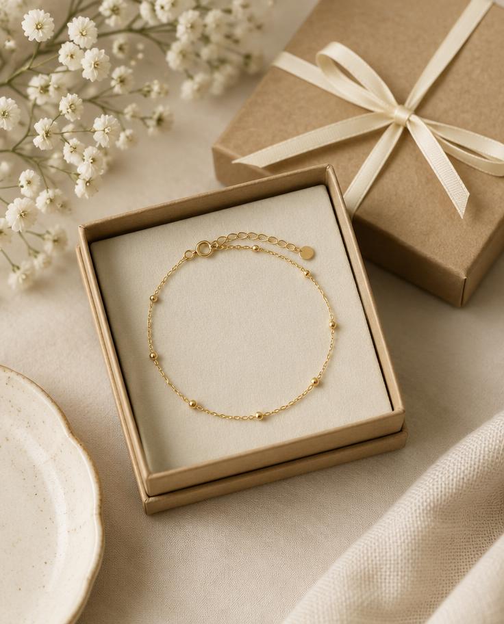 Dainty gold bracelet in a small ribboned gift box
